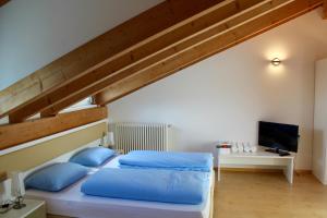 梅拉诺曼佐尼客房酒店的一间卧室配有一张带蓝色枕头的床
