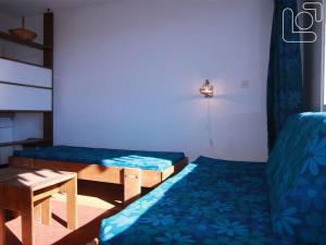 拉普德兹Appartement Huez, 1 pièce, 4 personnes - FR-1-405-65的客房设有两张床、一张桌子和一盏灯。