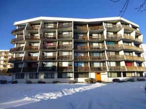 拉普德兹Appartement Huez, 1 pièce, 4 personnes - FR-1-405-65的公寓大楼前面有雪