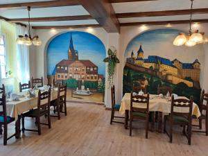 LuckaHotel zum Hirsch的一间拥有城市壁画的用餐室