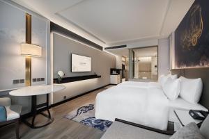 曼谷苏拉翁塞格兰德中心大酒店的卧室配有白色的床和桌子