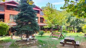 萨潘贾Sapanca Gönül Sofram Hotel & Bungalow & Villas的带有野餐桌和树的房子