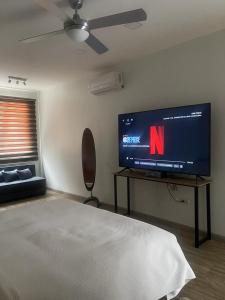 瓜亚基尔Kiran Lodging Guayaquil的一间卧室设有平面电视和一张床。