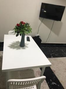 开罗Comfort suite的白色的桌子,上面有红色花瓶