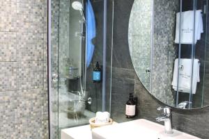 Banana Leaf Beachfront Exotic Room in Batroun的带淋浴、水槽和镜子的浴室