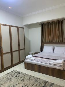 开罗Comfort suite的一间卧室配有一张大床和木制床头板