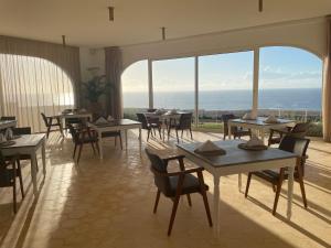 沃利迪耶Villa La Falaise的一间带桌椅的海景餐厅