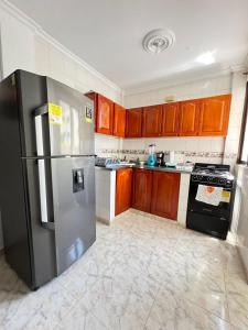 卡塔赫纳Apartamento Vacacional Cartagena Colombia的厨房配有不锈钢冰箱和木制橱柜