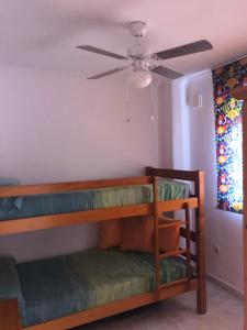 库姆布勒德尔索尔Paraíso的客房设有两张双层床和吊扇。