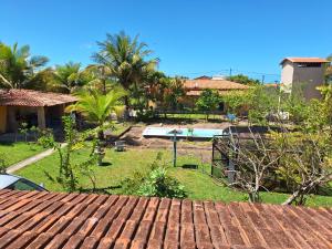 Costa DouradaCasa na Praia com Piscina的享有后院的景色,后院拥有游泳池和棕榈树