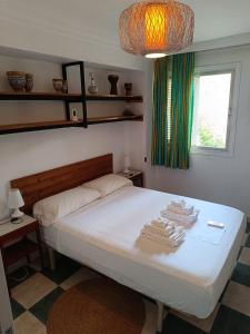 拉利内阿-德拉康塞普西翁room private bathroom in shared apartment 50m from Gibraltar的一间卧室配有带毛巾的床