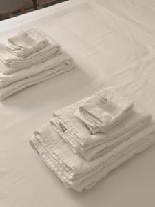 拉利内阿-德拉康塞普西翁room private bathroom in shared apartment 50m from Gibraltar的两堆白色毛巾,坐在床上