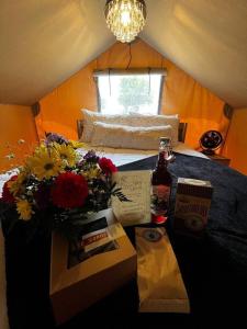 NavasotaIn A Meading - Safari Tent - BeeWeaver Honey Farm的一间卧室,配有一张带鲜花的桌子