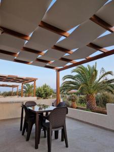古卡斯特隆Olivar Suites的一个带桌椅和棕榈树的庭院