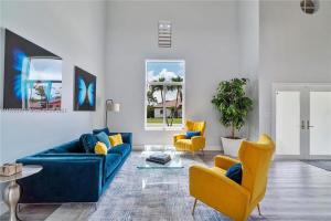 迈阿密Kendall Vacation Luxury Home的客厅配有蓝色的沙发和黄色的椅子