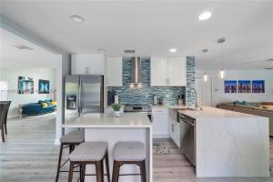 迈阿密Kendall Vacation Luxury Home的厨房配有白色橱柜和桌椅