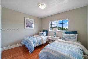 迈阿密Kendall Vacation Luxury Home的一间卧室设有两张床和窗户。
