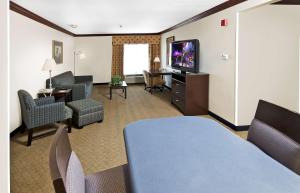 阿什伯勒阿什伯勒汉普顿酒店的酒店客房设有带电视和椅子的起居区。