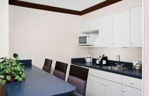 阿什伯勒阿什伯勒汉普顿酒店的厨房配有白色橱柜和蓝色台面