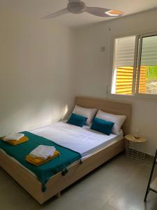 哥西尔Charmante maison avec jacuzzi的一间卧室配有一张带蓝色枕头的床和一扇窗户。