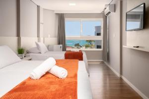 弗洛里亚诺波利斯Boulevard Beach Canasvieiras Hotel的酒店客房设有两张床和大窗户。