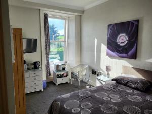 Lumphanan麦克白阿姆斯酒店的一间卧室设有一张床和一个窗口
