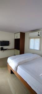 海得拉巴Clapping Leaves Resort的一间卧室设有一张大床和一个窗户。