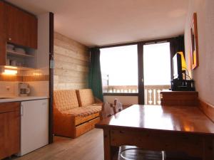 于埃Appartement Huez, 1 pièce, 4 personnes - FR-1-405-183的厨房以及带沙发和桌子的客厅。