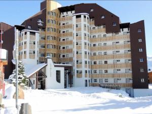 于埃Appartement Huez, 1 pièce, 4 personnes - FR-1-405-183的大楼前的积雪中的一个大建筑