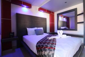 恩塞纳达港Hotel Hacienda的卧室配有一张带镜子的白色大床