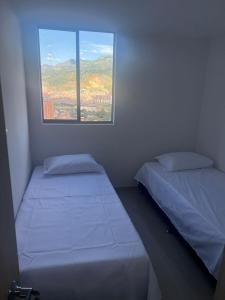 贝约Hermoso Apto con Vista al Ciudad y Parqueadero Gratis的小型客房 - 带2张床和窗户