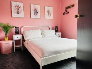 斯图尔特港The Heather Dew的粉红色的卧室设有白色的床和粉红色的墙壁