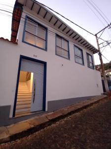 欧鲁普雷图Casa nova com suítes amplas的白色的房子,设有车库门和楼梯