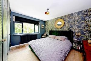 内勒惠特克Stunning, high end country house的一间卧室设有一张床和蓝色的墙壁