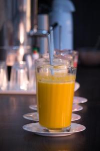 帕劳阿佩巴斯Maper Park Carajás的桌上盘子里的一杯橙汁