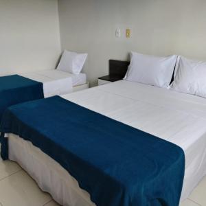 帕劳阿佩巴斯Maper Park Carajás的两张睡床彼此相邻,位于一个房间里