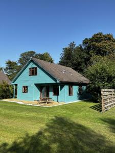 德里门Foxglove Cottages的院子里带野餐桌的蓝色房子