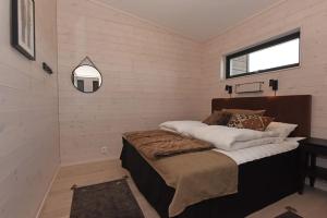 萨伦Timmerby Lodge - Lindvallen Sälen - Ski in Ski out的一间卧室设有一张床、一个窗口和一面镜子