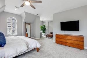 底特律The Lumber Baron's Penthouse 3BR / 2.5 BA的一间卧室配有一张床和一台平面电视