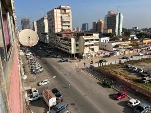 罗安达África em Zona Comercial de Luanda的一条城市街道,有汽车停在停车场