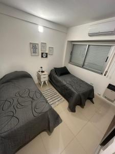 罗萨里奥Apartamento 2 habitaciones Pichincha的一间卧室设有两张床和窗户。
