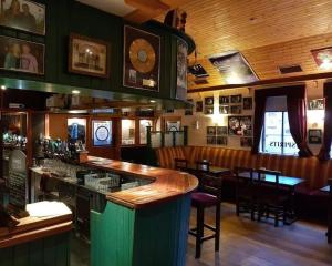 多尼戈尔Spacious Cottage in Meenaleck near Gweedore County Donegal的餐厅内的酒吧配有桌椅