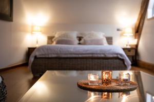 Le ChenoyDuo Détente的一间卧室配有一张床和一张带蜡烛的桌子。