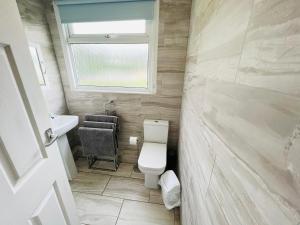 桑当2 Bedroom Chalet SB22, Sandown Bay, Isle of Wight, Dog Friendly的一间带卫生间、水槽和窗户的浴室