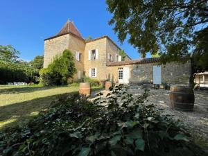 DuravelChâteau la Gineste - Castle and Vineyard的一座古老的石头建筑,前面有桶