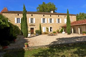 DuravelChâteau la Gineste - Castle and Vineyard的前面有树木的大型砖砌建筑