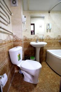 撒马尔罕Hotel Plaza 777的浴室配有卫生间、盥洗盆和浴缸。