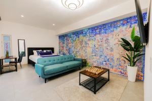 棕榈滩Privada Stays - Lofts with Private Pool and Oasis, near Eagle Beach的客厅配有蓝色的沙发和床。