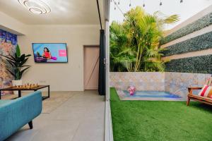 棕榈滩Privada Stays - Lofts with Private Pool and Oasis, near Eagle Beach的带电视的客厅和花园。