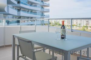 卡耐特蒂贝兰格Apartamento de lujo con 2 habitaciones en Canet d'en Berenguer的一张桌子,上面放着一瓶葡萄酒和两杯酒
